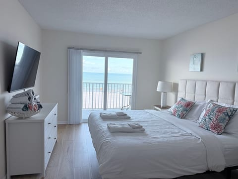 Bright beachfront bedroom with private balcony and ocean views