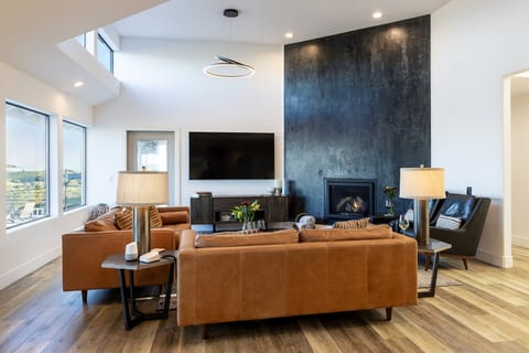 Soaring ceilings, skylights, a dramatic floor-to-ceiling fireplace wall, and vineyard views just beyond the glass. The great room is as grand as the setting it was built for.