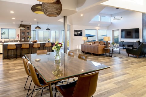 One seamless, sun-drenched space where the kitchen, dining room, and living room flow together beneath soaring ceilings — with the entire Paso Robles valley as the backdrop.