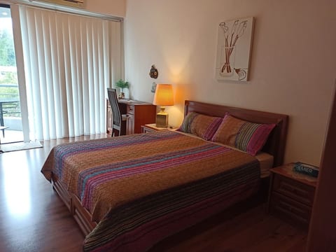Spacious master room with attached bathroom with tub,hot waterm air condiotioner and wall fan.