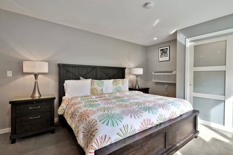 The enclosed bedroom pairs a king bed with two nightstands and a closet.