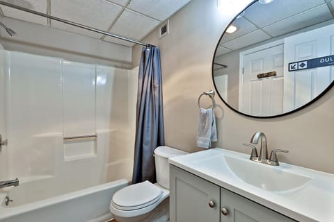 The full bathroom has a tub and shower combination with a vanity for getting ready.
