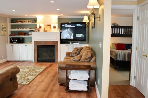 The living room opens toward the bedroom, with the gas fireplace beside the television.