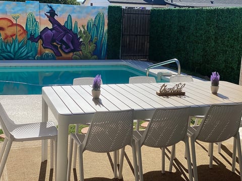 Outdoor dining overlooking the pool and mural