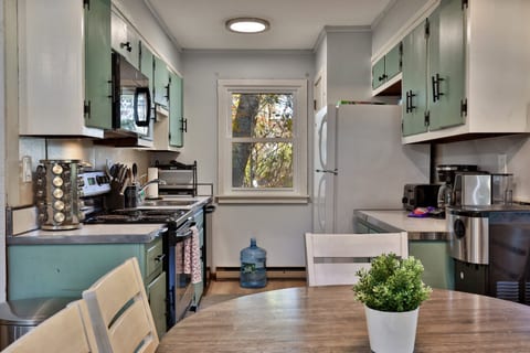 Prepare meals in the kitchen, with a stove, oven and microwave ready for cooking.