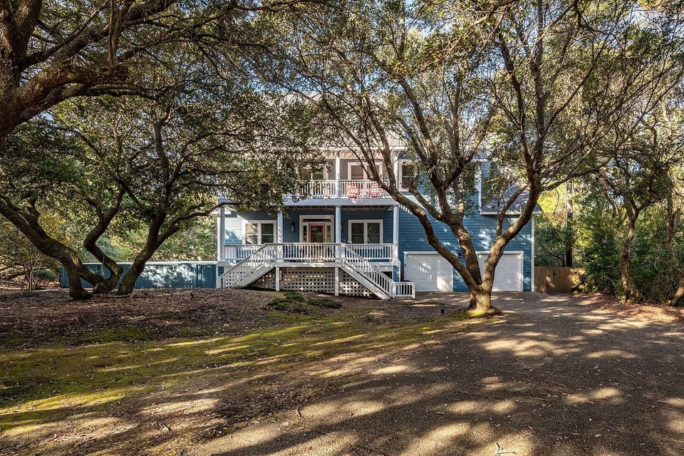 Front of house adorned with Live Oaks