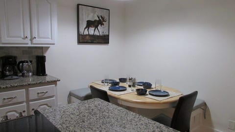 Dining table sits 4 to 6, with storage under the benches. Two additional people could sit at the island with provided bar stools.
