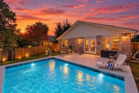 As the sky turns pink and gold, you slide into water that's still warm from the day — string lights flicker on, and the whole yard feels like it's just for you.