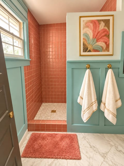 Chic coral-tiled shower with bright natural light and boutique-style details