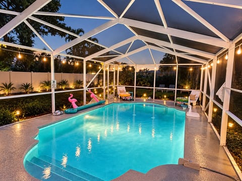 Screened private pool with string lights for relaxing evening swims