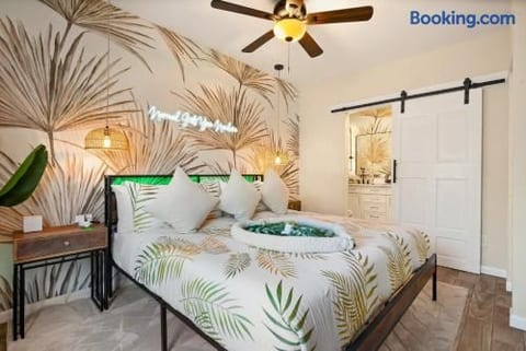 Tropical-inspired bedroom with en suite bath and stylish barn door