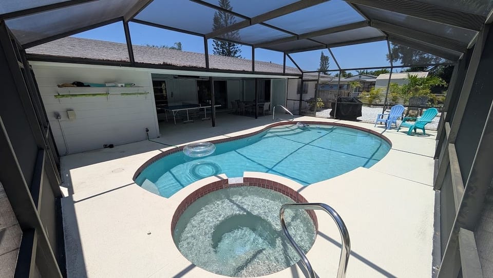 Backyard Oasis: Dive into relaxation with a sparkling pool and spa, surrounded by lush greenery!