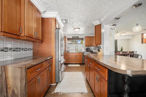 Fully equipped kitchen with stainless steel appliances including French Door refrigerator with water and ice maker in door, glass electric stove, oven, microwave, coffee maker, electric tea kettle, dishes, cooking and baking pans, pots