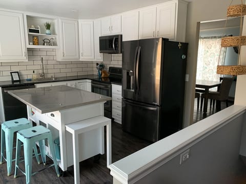 Full kitchen with island and access to deck/backyard.