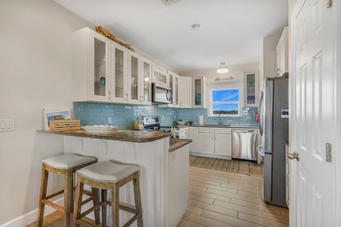Pull up a stool at the bar and keep the cook company — coffee in the morning, drinks before dinner, the whole kitchen open to the rest of the house.