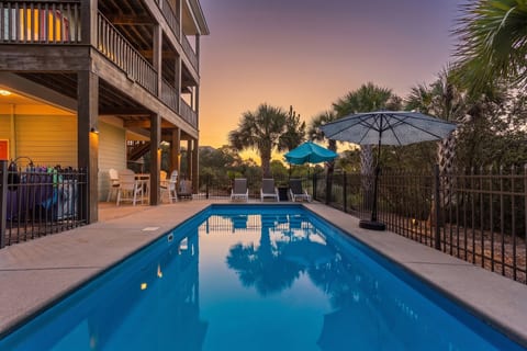 Slip into the pool as the sky goes orange over the dunes — the house lit up above you, the Gulf a few streets away. Your own private pool, no resort crowd to share it with.
