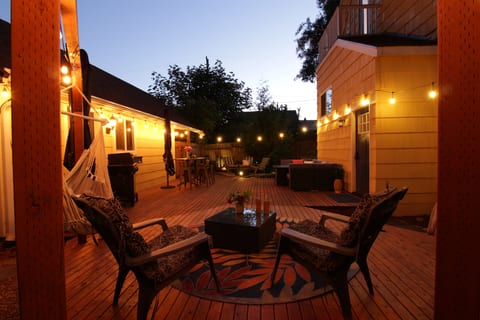 As the sun goes down, the deck settles into a cozy evening retreat with glowing string lights and plenty of space to lounge, dine, and enjoy the outdoors.