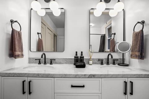 The newly renovated full bathroom downstairs features a double vanity and a bathtub, offering a bright, modern space that's perfect for getting ready or unwinding after a day of exploring Napa Valley.