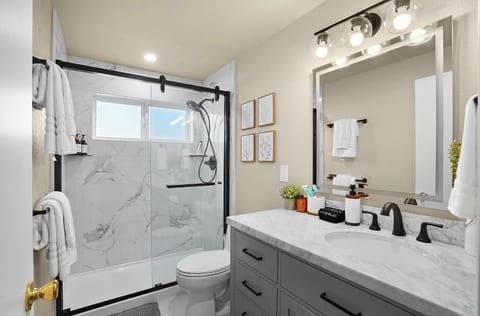 Newly renovated full bathroom with a spacious glass-enclosed shower, modern vanity, and fresh, clean finishes throughout.