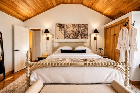 Primary suite with king bed, spa robes, vaulted wood ceilings & blackout blinds.