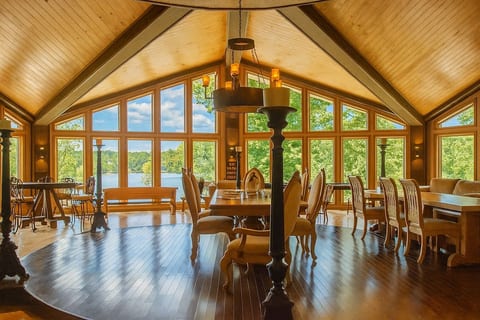 Our Great Room, Edwin Hall. A spacious room with lake views, fireplace, dining table and seating vignettes, designed for large groups to gather together.