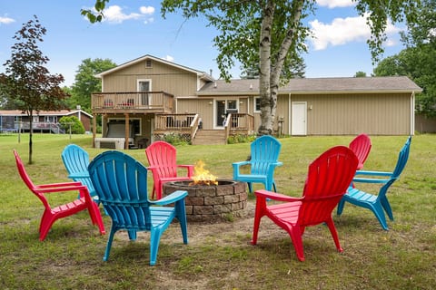 Fire pit fun: Enjoy laughter and warmth around vibrant chairs under a starlit Traverse City sky!