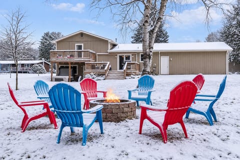 Fire pit fun: Enjoy laughter and warmth around vibrant chairs under a starlit Traverse City sky!