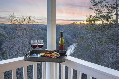 Enjoy the river and mountain views from the deck. Balcony Retreat: Indulge in fine wine and snacks as nature's hues enchant your evenings!