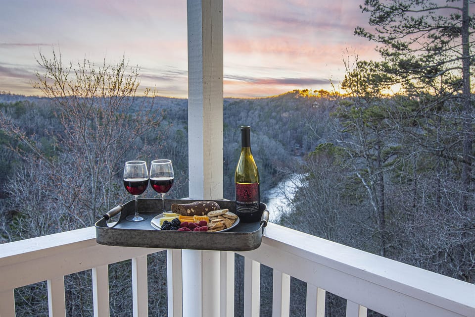 Enjoy the river and mountain views from the deck. Balcony Retreat: Indulge in fine wine and snacks as nature's hues enchant your evenings!