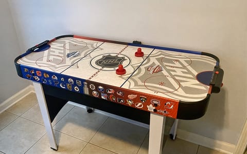 Air hockey table in kids room. Kids' Game Room: Battle it out with friends on this thrilling air hockey table!