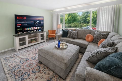 Spacious living room featuring a sleek 65 inch TV, ideal for entertainment and cozy time at home