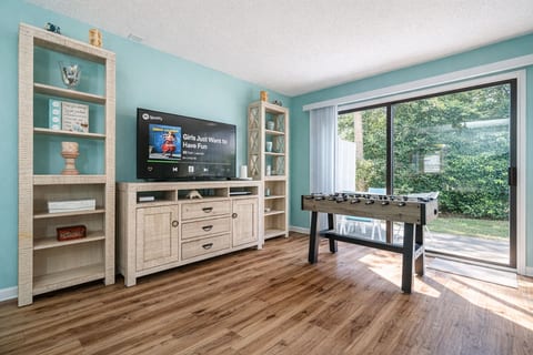 Living Room: Bright and airy space with foosball fun & views of lush palm trees outside!