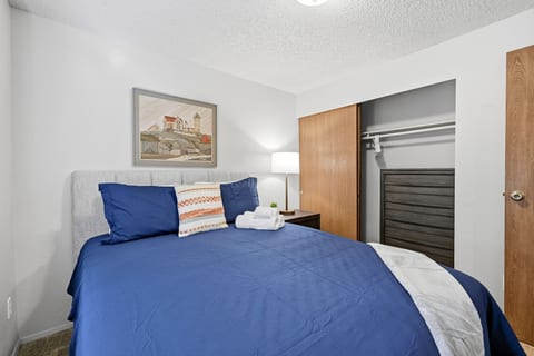 Cozy bedroom with plush blue bedding and convenient closet storage