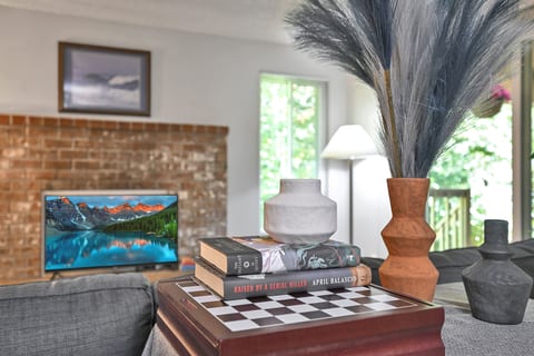 Cozy living room with brick fireplace, natural light, and stylish decor
