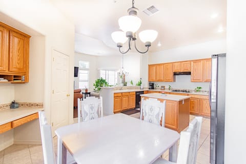Bright open kitchen with island, dining space, and dedicated workspace