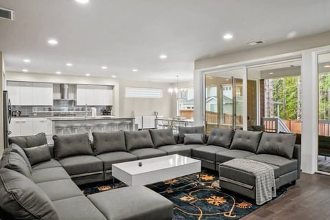This expansive living room features three cozy sofas that easily convert into beds, offering flexible sleeping space for guests. A large TV anchors the room, making it perfect for movie nights, relaxing, or hosting in a stylish, comfortable setting