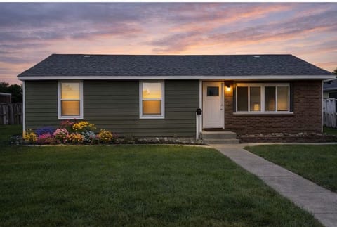 Cozy ranch with sunset curb appeal, fenced yard & vibrant garden.