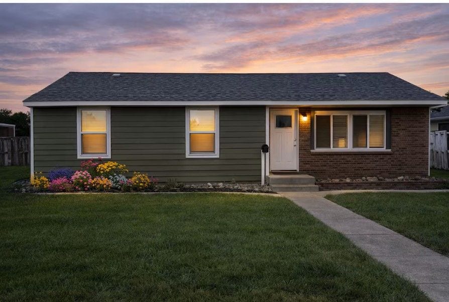 Cozy ranch with sunset curb appeal, fenced yard & vibrant garden.