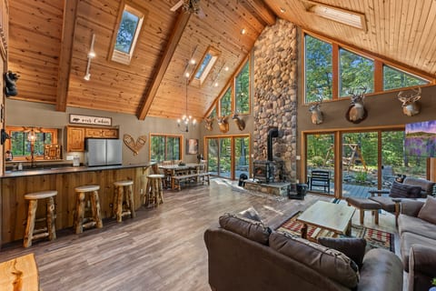 Soaring ceilings, stone fireplace & forest views in this stunning cabin great room