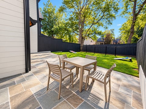 Private fenced patio and sunny backyard with outdoor dining