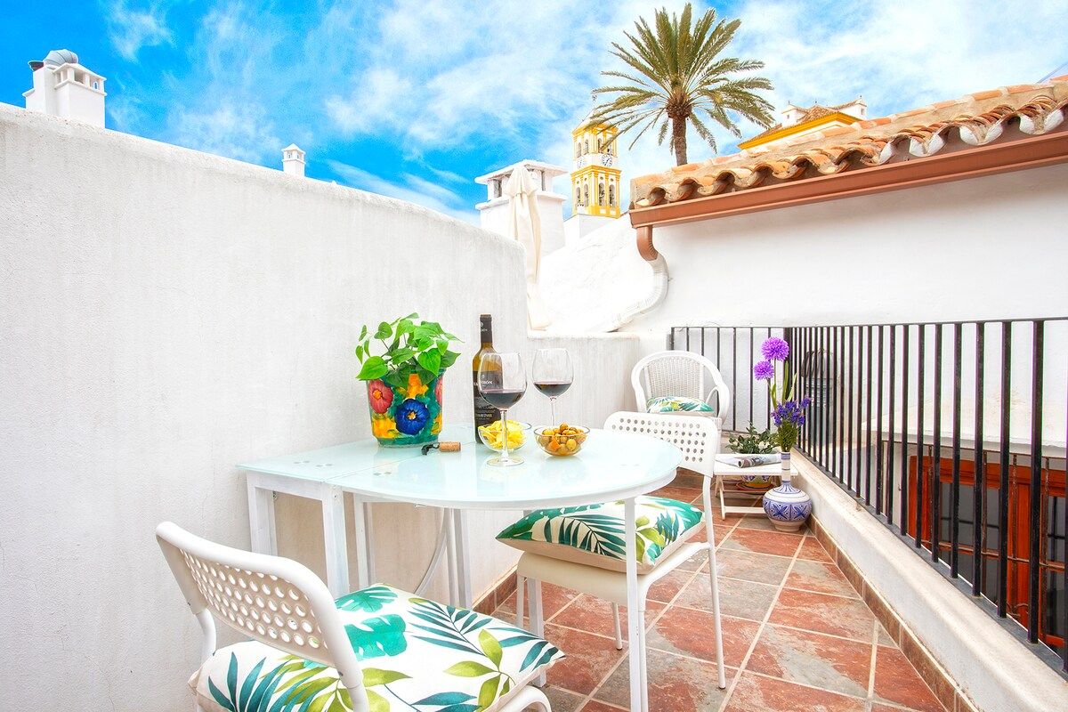 Private terrace with tables to enjoy a glass of wine at sunset with views of the rooftops of the old town