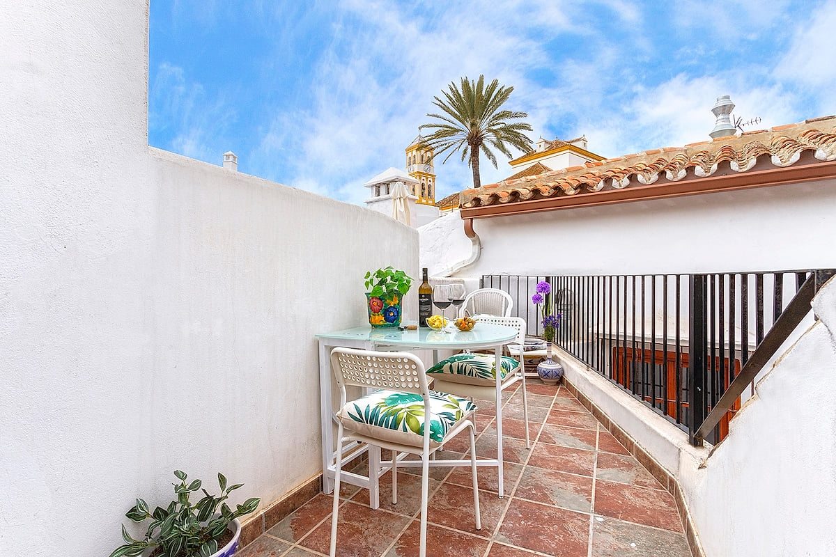 Private terrace with tables to enjoy a glass of wine at sunset with views of the rooftops of the old town