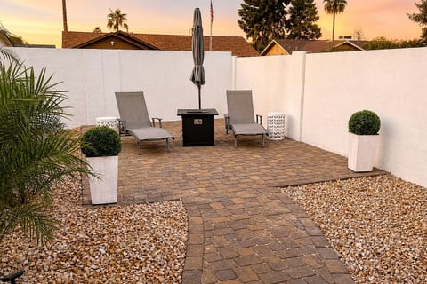 Private patio with loungers, fire pit table, and sunset ambiance