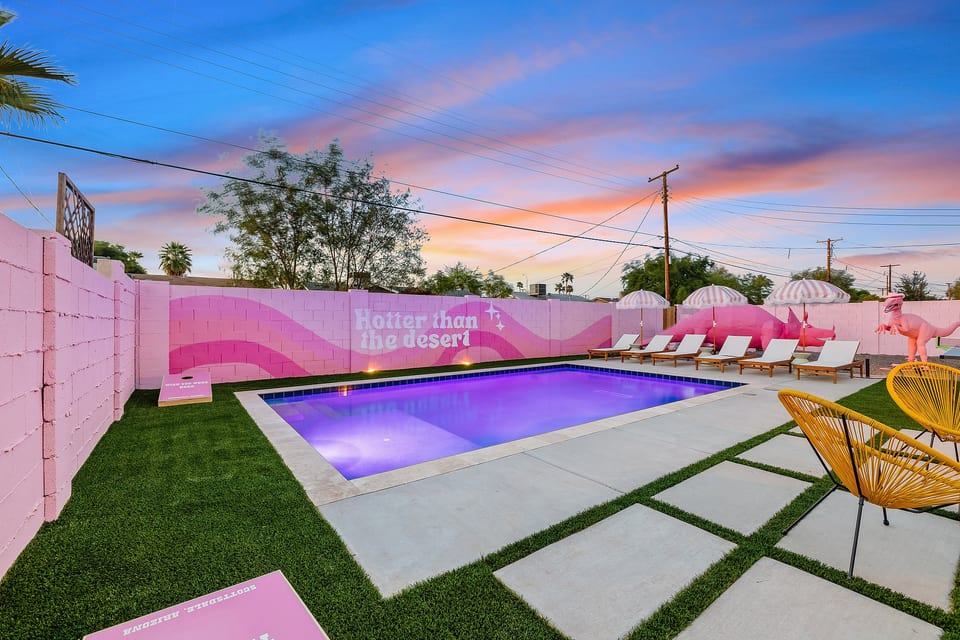 Pink desert pool oasis with loungers, sunset views, and playful resort vibes