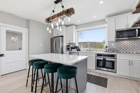 Bright chef’s kitchen with island seating, stainless suite, and views.