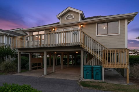 Escape to this charming raised cottage just steps from the beach. Relax on your spacious deck and enjoy the ocean breeze, with ample covered parking below for convenience.