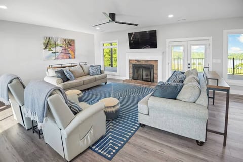 Spacious living room with plush seating, smart TV, fireplace, and lake views.