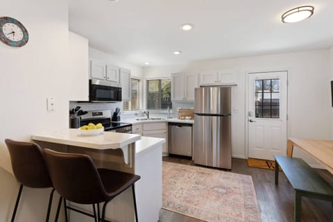 You'll love this fully-equipped kitchen with stainless steel appliances, a cozy breakfast bar, and stylish barstools, perfect for a quick snack or a morning coffee.
