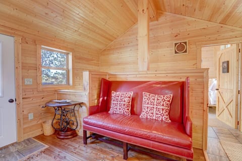 Classic cabin character meets comfort with this high-back red leather bench nestled beneath vaulted pine ceilings, ideal for reading, sipping coffee, or simply unwinding.