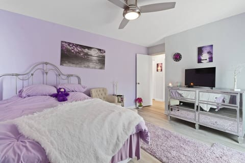 Escape to this tranquil, lavender-hued bedroom. Relax in the plush bed with a soft throw, catch up on shows, or simply unwind in your cozy, private retreat.